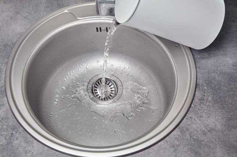 pouring water from kettle into sink